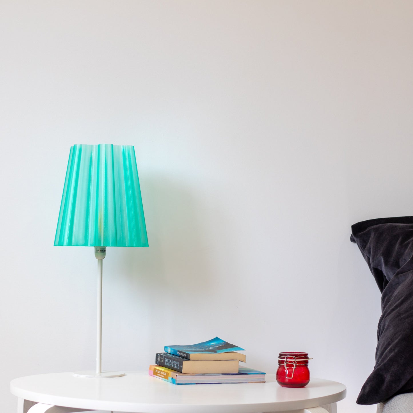 Translucent teal lamp shade with lights off, showcasing its sleek design and modern aesthetic on a minimalist bedside table. 3D printed semi-transparent lamp shade. Minimalistic looking lamp shades manufactured using 3D printing technology. Elevates the look of any room.